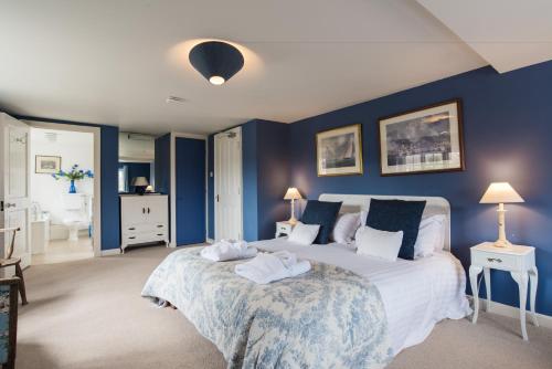 a bedroom with a large bed with blue walls at Tapnell Manor At Tapnell Farm in Yarmouth