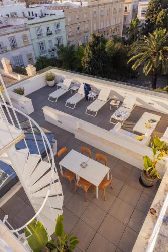 a patio with a table and chairs on a building at Candelaria10 in Cádiz