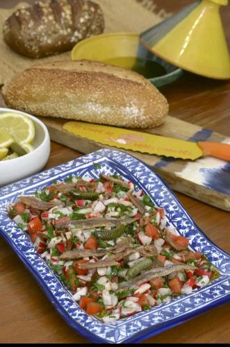 a plate of food on a table with bread and vegetables at Les Sons du Jardin Monastir in Monastir