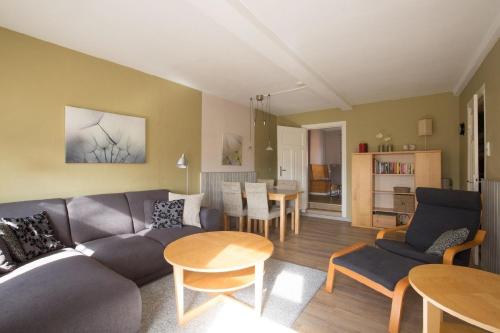 - un salon avec un canapé et une table dans l'établissement Appartement in Pellworm mit Garten, Terrasse und Grill, à Pellworm