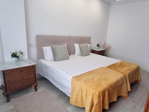 a bedroom with a large bed with a yellow blanket on it at Apartamento Larisa in Nájera