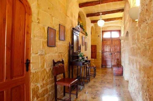 un corridoio con sedie e tavolo in un edificio di Villa Harruba a Xagħra
