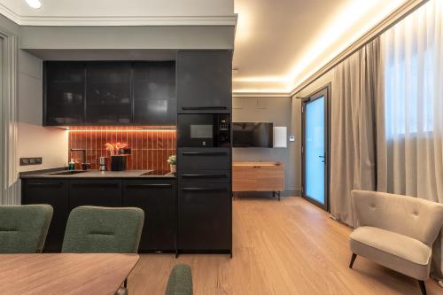 una cocina con armarios negros, mesa y sillas en Old Town Apartments by Staynnapartments en Bilbao
