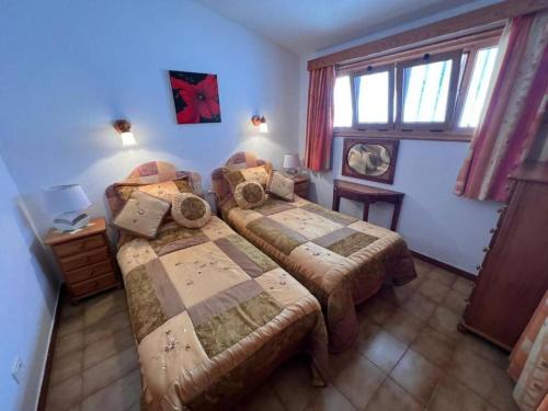 1 dormitorio con 2 camas y ventana en Vista Mar y piscina climatizada, en Arona