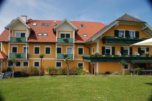 a large yellow building with red roof at Weinberg-Panoramaferienhaus in Kitzeck im Sausal