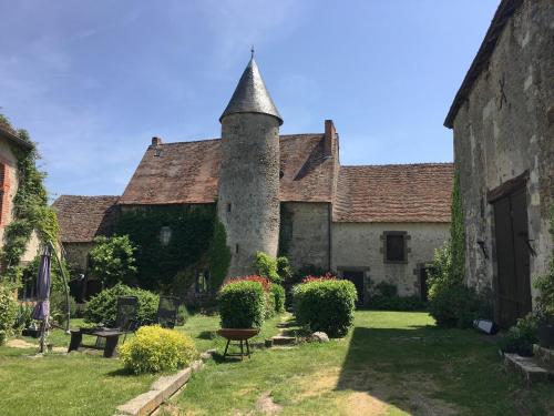 an old building with a tower in a yard at Chateau Mareuil in Brigueuil-le-Chantre