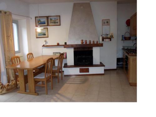 eine Küche mit einem Holztisch und einem Kamin in der Unterkunft Apartment Fico in Tignale
