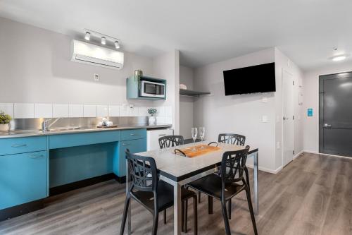 a kitchen with blue cabinets and a table and chairs at Tasman Holiday Parks - Christchurch in Christchurch