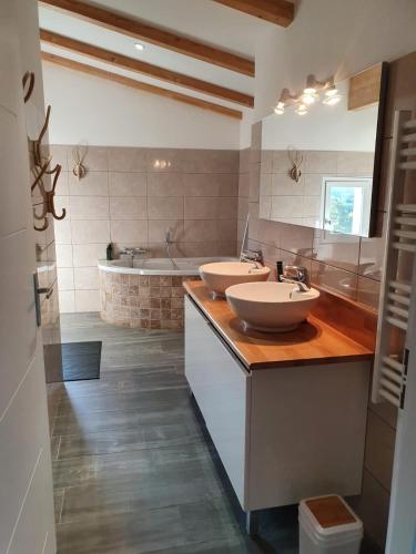 une salle de bain avec deux lavabos et une baignoire dans l'établissement Appartement T4 Notta Bene - entre mer et montagne, à Porto-Vecchio