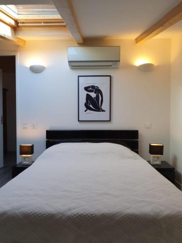 - une chambre avec un lit blanc et deux lampes dans l'établissement Appartement T4 Notta Bene - entre mer et montagne, à Porto-Vecchio