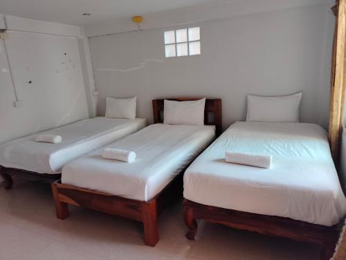 two twin beds in a room with a window at Thosawan Resort ทศวรรณ รีสอร์ท in Khong Chiam
