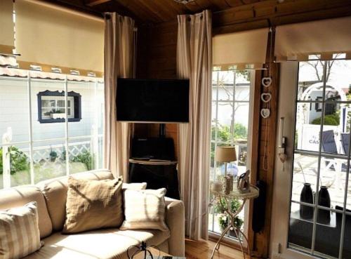 a living room with a couch and some windows at Ferienhaus De Graaf mit einer sonnigen Terrasse und Garten IJsselmeer in Wervershoof