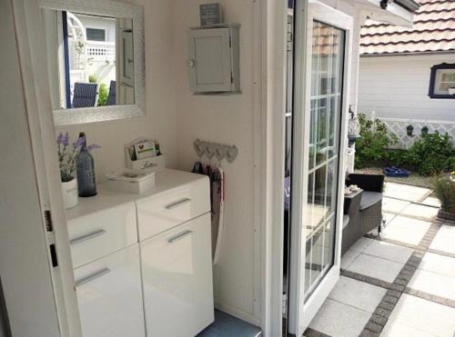 a kitchen with white cabinets and a mirror at Ferienhaus De Graaf mit einer sonnigen Terrasse und Garten IJsselmeer in Wervershoof