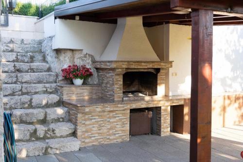 an outdoor brick oven with a flower pot at Villa Kamena with Pool, Jacuzzi & Sauna in Grude