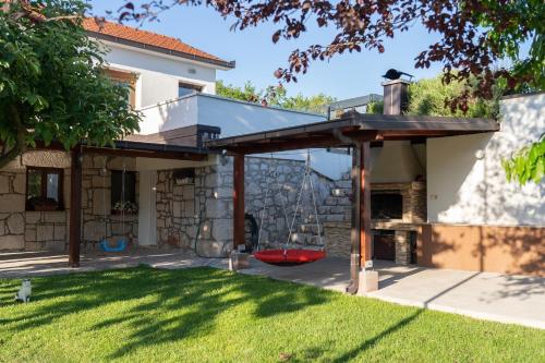 an outdoor patio with awning in a yard at Villa Kamena with Pool, Jacuzzi & Sauna in Grude