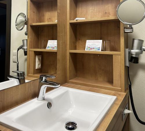 a bathroom with a sink and a mirror at Hotel Konradshof in Bad Griesbach