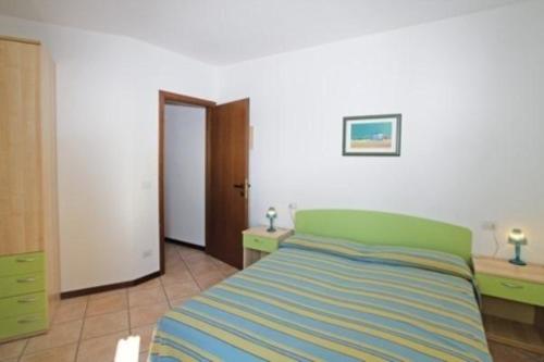 ein Schlafzimmer mit einem Bett, zwei Schreibtischen und einer Tür in der Unterkunft Wohnungen in Ferienanlage in Bibione