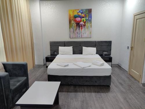 Habitación de hotel con cama y silla en SECRET HOTEL en Bakú