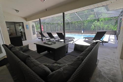 a living room with a couch and chairs and a pool at Your Manatee and Scalloping Adventure Retreat in Crystal River in Crystal River