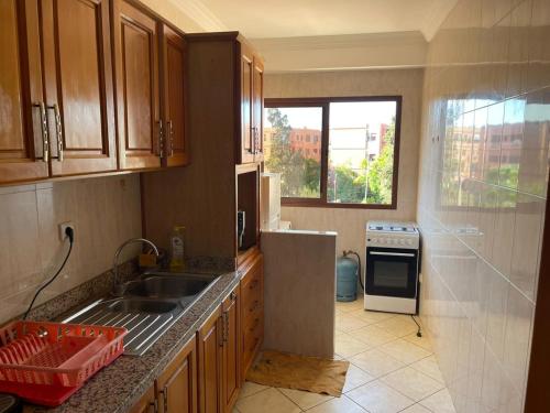 une cuisine avec évier et cuisinière ainsi qu'une fenêtre dans l'établissement Superbe appartement à Marrakech quartier Majorelle 2 chambres, à Marrakech