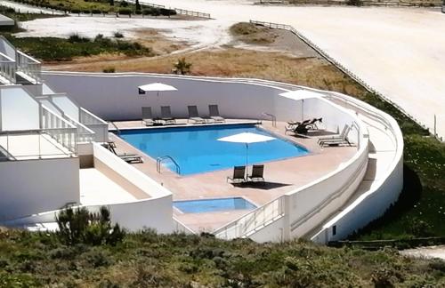 uma vista superior de uma piscina com guarda-sóis em By the Beach - Praia d'el Rey Golf & Beach Resort em Óbidos