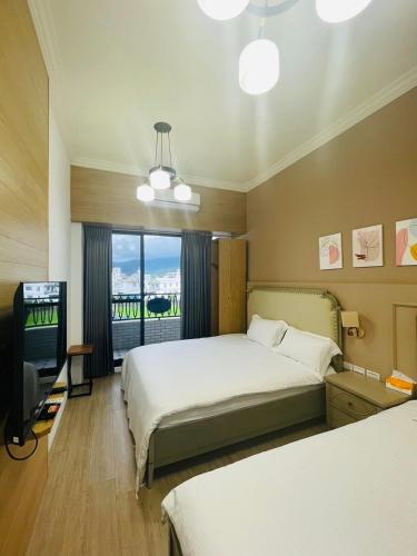 a hotel room with two beds and a television at Good Times BnB in Chishang