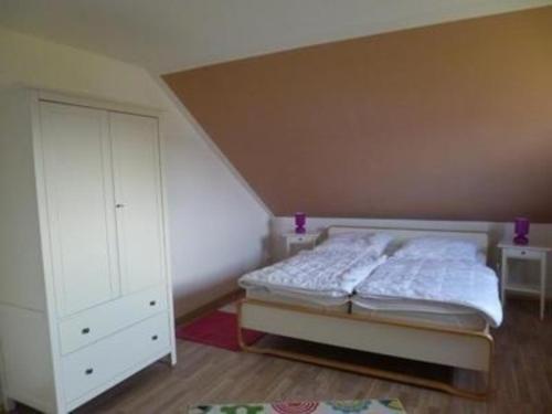 1 dormitorio con 1 cama y armario blanco en Ferienhaus in Hoben mit Grill und Terrasse, en Zierow