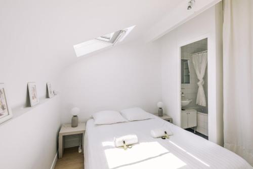 a white bedroom with a white bed and a mirror at GuestReady - Radiance in comfort near Paris in Saint-Cloud