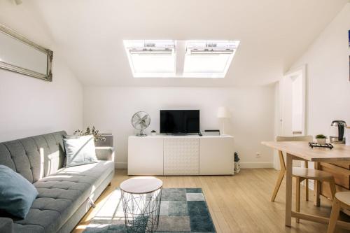 a living room with a couch and a tv at GuestReady - Radiance in comfort near Paris in Saint-Cloud