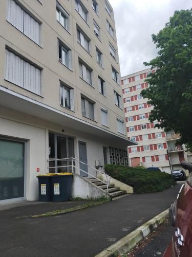 un immeuble d'appartements avec un parking en face de celui-ci dans l'établissement Lumière et Espace, Lyon et Pilat à votre Portée, à Rive-de-Gier