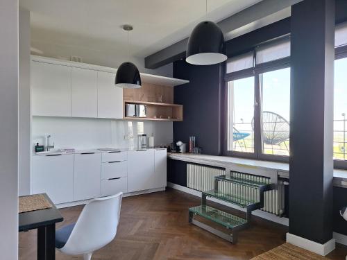 a kitchen with white cabinets and a table and a window at Apartament Wiejska 9 in Warsaw