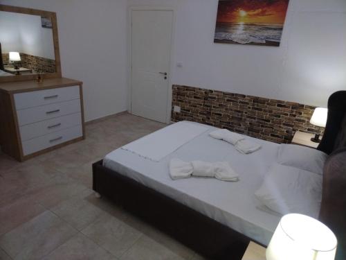 a bedroom with a bed with towels on it at Apartment TEONA in Sarandë
