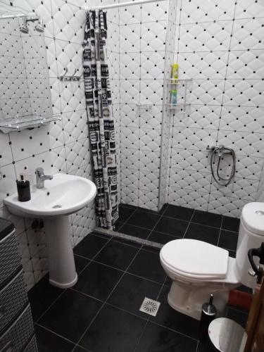 a bathroom with a white toilet and a sink at Apartment TEONA in Sarandë