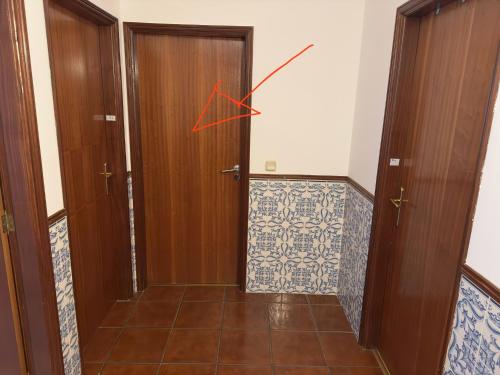 una habitación con una puerta con una flecha roja en Edifício paraíso, en Bragança
