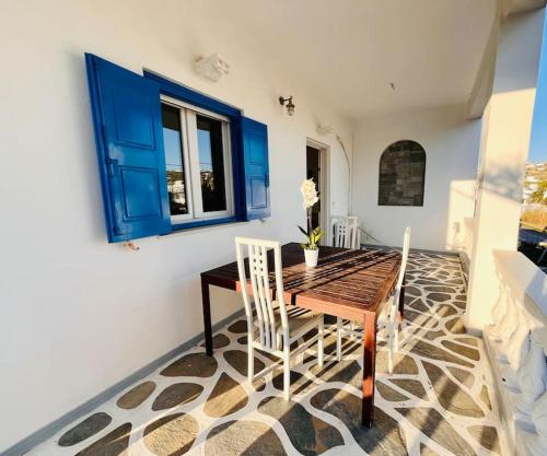 a dining room with a wooden table and chairs at Serenity House Ornos in Ornos
