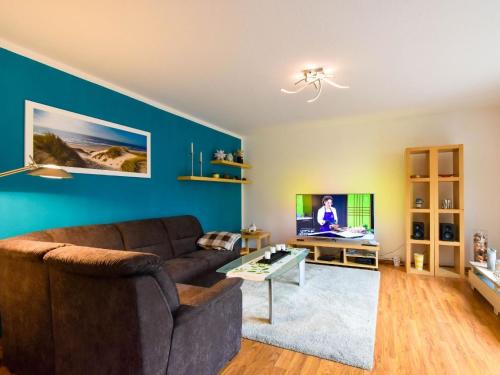 a living room with a couch and a tv at Ferienwohnung Ostseestern für 4 Personen in Wiek auf Rügen