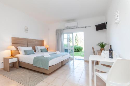 a bedroom with a bed and a table and a television at Atalaia Sol Aparthotel - tennis & heated pool in winter in Lagos