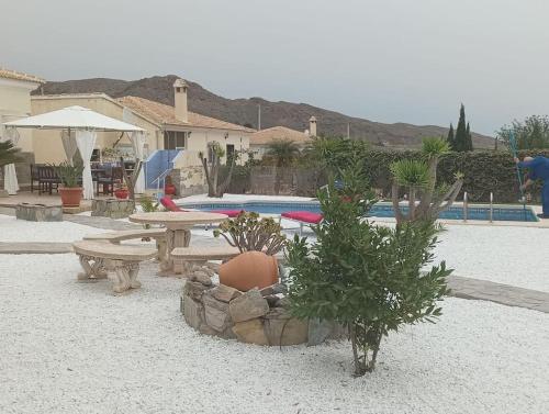 einen Innenhof mit einem Picknicktisch und einem Pool in der Unterkunft Villa Paz - Villa Familiar para 6 con piscina, AC, Wifi y parking in Arboleas