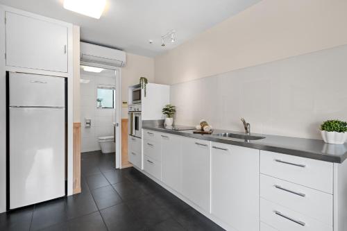 a white kitchen with a sink and a toilet at Tasman Holiday Parks - Christchurch in Christchurch