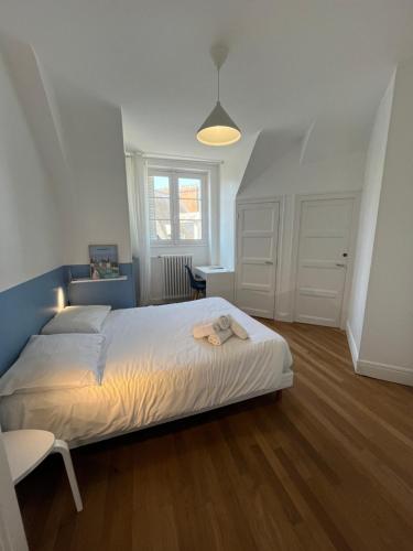 une chambre avec un lit, une table et une fenêtre dans l'établissement Le Wilson - Vue Imprenable sur la Loire et le château de Blois, à Blois