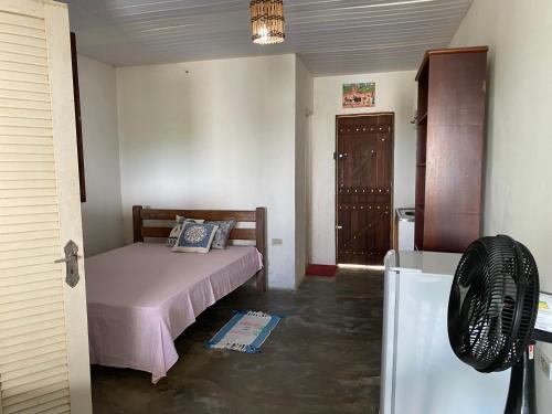 ein kleines Schlafzimmer mit einem Bett und einem Kühlschrank in der Unterkunft Casa da Pedra in Bezerros