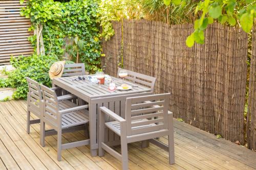 une table et des chaises en bois sur une terrasse en bois dans l'établissement Sweet Dream - Quiet - Host Provence, à La Seyne-sur-Mer
