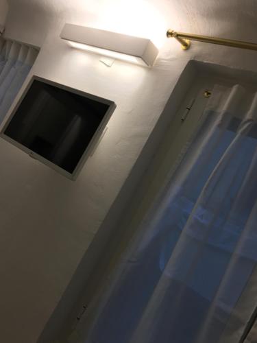 einen Flachbild-TV an einer Wand neben einer Tür in der Unterkunft Il Piccolo Giustiniani 20 in Genua