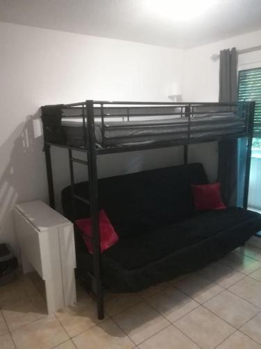 Cette chambre comprend un lit superposé noir et un canapé. dans l'établissement Studio B Front de Mer, à Saint-Raphaël