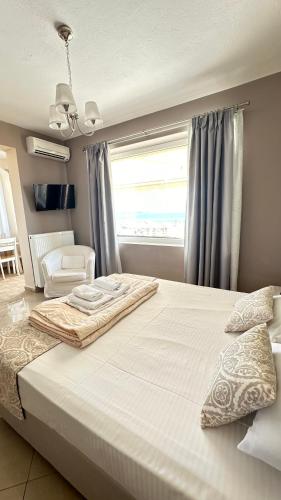 a bedroom with a large white bed with a window at Gorgona Di Thassos in Limenaria