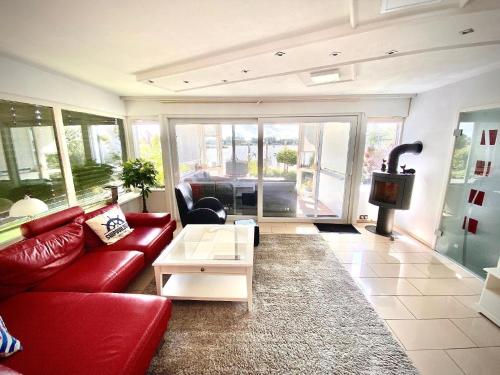 a living room with a red couch and a table at Ferienhaus direkt am See in Wervershoof