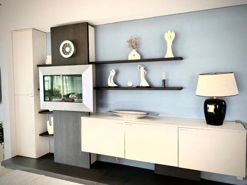 a living room with a white cabinet and shelves at Ferienhaus direkt am See in Wervershoof