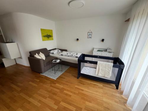 ein kleines Wohnzimmer mit einem Bett und einem Sofa in der Unterkunft Apartment Riedwiese in Hörbranz