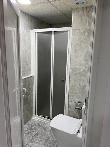 a bathroom with a toilet and a glass shower at İZAN VİLLA BAKIŞ APARTMENTS in Bodrum City