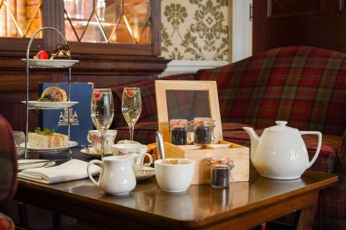 a table with dishes and wine glasses on it at Owston Hall Hotel in Doncaster